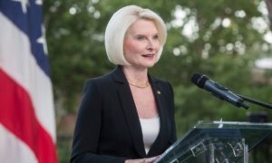 Ambassador Gingrich giving a speech outside at a lectern